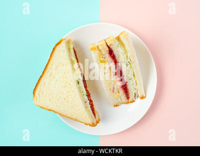 Sandwich coréen branché inkigayo associé à k-pop culture sur une plaque blanche sur deux couleurs pastel arrière-plan, Vue de dessus, l'orientation horizontale Banque D'Images