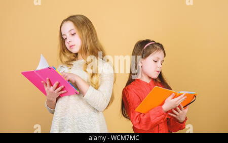 Heureux les petits enfants prêts pour l'école leçon. les élèves de lire un livre. Projet d'école. Amitié et fraternité. de cahiers d'écriture. Retour à l'école. les petites filles avec note books. La découverte de la guérison. Banque D'Images