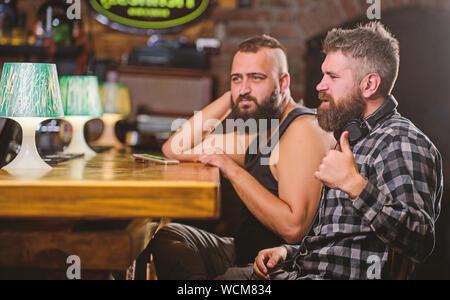 Vendredi détente dans un bar. Hipster barbu dépenser à loisir comptoir bar. Commander des boissons au bar. Les hommes avec le smartphone se reposent au bar. Dépendance Mobile concept. Téléphone mobile toujours avec moi. Banque D'Images