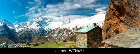 Vue panoramique de refuges en pierre avec Monte Disgrazia couvertes de neige en arrière-plan, l'Alpe Oro, Valtournenche, Valtellina, Lombardie, Italie Banque D'Images