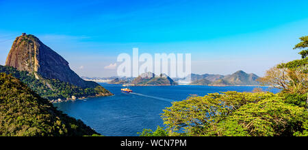 Cargo arrivant à l'entrée de la baie de Guanabara à Rio de Janeiro avec forêt, mont du Pain de Sucre et de Niteroi ville en arrière-plan Banque D'Images