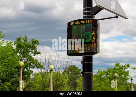 Un signe de vitesse radar bilingue grâce un passant pour respecter la limite de vitesse affichée en anglais et en français. Banque D'Images