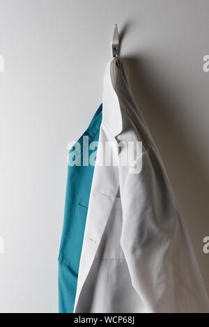 Les médecins d'un sarrau blanc et vert des gommages corporels suspendu à un crochet. Banque D'Images