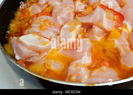 Faire de sauce ou vinaigrette pour les pâtes. Savoureux légumes frais, tomates, oignons, poivre, frit dans une poêle profonde avec des tranches de viande de poulet. Foc sélective Banque D'Images