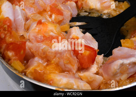 Faire de sauce ou vinaigrette pour les pâtes. Savoureux légumes frais, tomates, oignons, poivre, frit dans une poêle profonde avec des tranches de viande de poulet. Foc sélective Banque D'Images