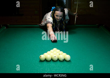 Senior woman briser le triangle de boules de billard, sur un billard et d'apprendre à démarrer jeu de billard russe. Focus sélectif. Close-up. Banque D'Images