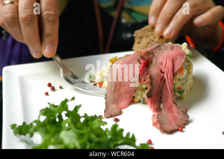 Délicieux dîner. Manger de la salade traditionnelle pour les peuples slaves Olivier ou salade de légumes et de viande au café ou restaurant à partir de la plaque blanche. Séle Banque D'Images