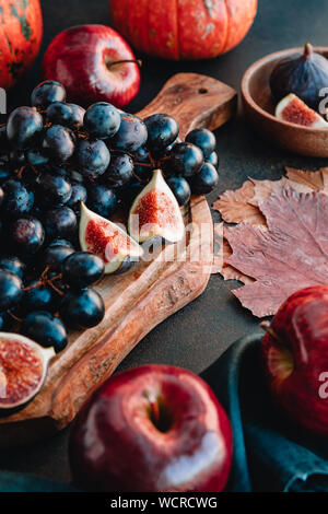 Les aliments d'automne Nature morte avec fruits et légumes de saison comme Bangalore du raisin bleu, rouge les pommes et figues sur une table. Banque D'Images