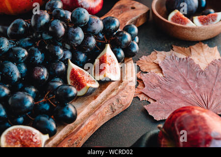 Les aliments d'automne Nature morte avec fruits et légumes de saison comme Bangalore du raisin bleu, rouge les pommes et figues sur une table. Banque D'Images