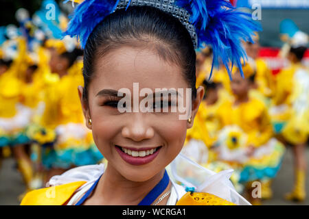 Filipino écolières secondaire concurrence dans le Tambor Trumpa Martsa Musika (Drum & Bugle) Concours, Festival Dinagyang, Iloilo City, le Phi;ippines. Banque D'Images