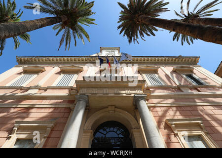 L'hôtel de ville d'Ajaccio encadrée par des feuilles de palmier, Corse, France. Banque D'Images