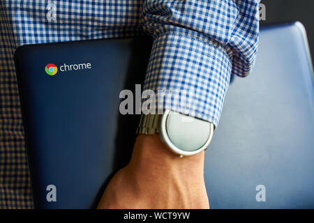 Bichkek, Kirghizistan - juin 6, 2019 : Asus Chromebook dans la main de l'homme à regarder sur elle. Banque D'Images