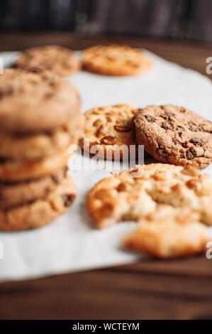 Les cookies au chocolat sur le papier parchemin. Broken biscuits sur une table en bois. Focus sélectif. Banque D'Images