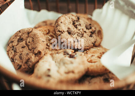 Les cookies au chocolat se trouve dans un panier en osier. Un panier avec des cookies sans gluten sur une table en bois. Focus sélectif. Banque D'Images