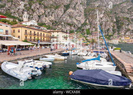 Sur le lac de Garde Limone nouveau port avec bateaux amarrés, côtes et hors-bords. Les touristes se promènent le long de la mer. Banque D'Images