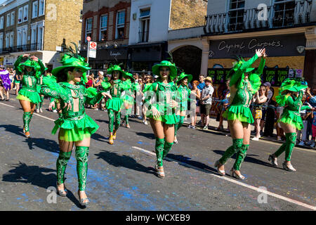 26 août 2019 - Les femmes habillés en costume vert dansant dans la parade, le carnaval de Notting Hill sur une banque chaud lundi férié, Londres, Royaume-Uni Banque D'Images