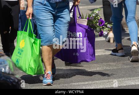 Bucarest, Roumanie - 13 août 2019 : People shopping traverser une rue à Bucarest. Banque D'Images