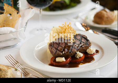 Un filet mignon de boeuf le dîner avec un verre de vin rouge dans un bon restaurant. Banque D'Images