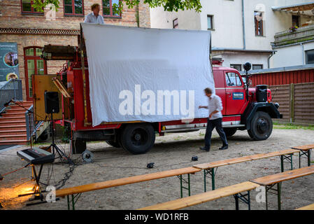 Waren, Allemagne. Août 28, 2019. Les musiciens Tobias Note (ci-dessous) et Stephan Gunthard (ci-dessus) de préparer leur cinéma fire brigade avec l'écran pour la soirée projection de différents films muets. Voyager avec leur cinéma, un ancien pompier Magirus Deutz construit en 1969, les deux musiciens étudiés voyager dans toute l'Allemagne. Tous les genres de films muets sont indiquées - à partir de leur création en 1895 à la fin de l'époque du film muet autour de 1930. Credit : Jens Büttner/dpa-Zentralbild/dpa/Alamy Live News Banque D'Images