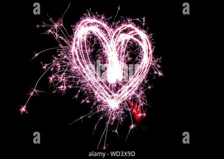 D'artifice en forme de coeur dans la nuit