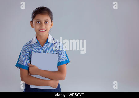 Portrait of a school girl holding books and smiling Banque D'Images