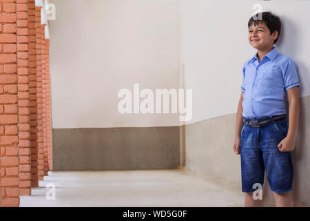 Portrait d'école garçon debout à l'extérieur de la classe Banque D'Images