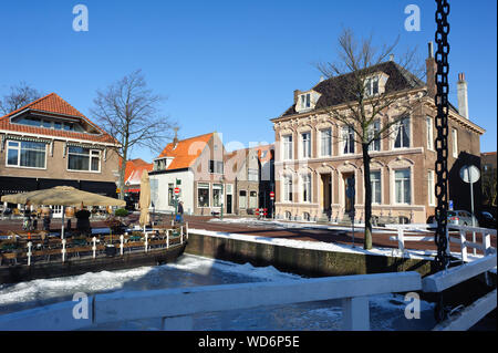 Hoorn, Noord-Holland / Pays-Bas - Mars 11, 2012 : l'eau gelée et montrer sur canal et vieux bâtiments traditionnels en briques avec des toits de tuile à sunny winte Banque D'Images