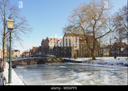 Hoorn, Noord-Holland / Pays-Bas - Mars 11, 2012 : l'eau gelée et montrer sur canal et vieux bâtiments traditionnels en briques avec des toits de tuile à sunny winte Banque D'Images