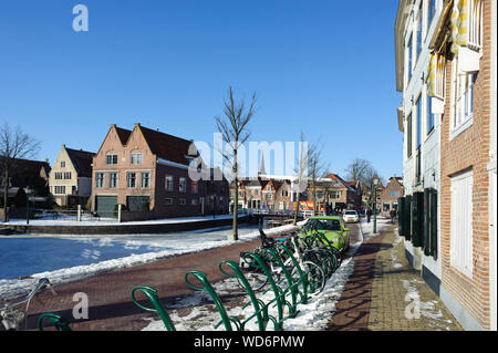 Hoorn, Noord-Holland / Pays-Bas - Mars 11, 2012 : l'eau gelée et montrer sur canal et vieux bâtiments traditionnels en briques avec des toits de tuile à sunny winte Banque D'Images