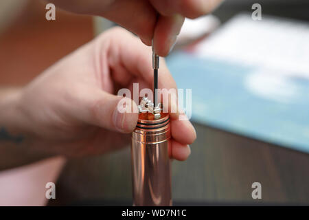 Vaping professionnel spécialiste des réparations de l'appareil.remplace l'ancien chef de la bobine avec le fil en cher mech mod.gadget cigarette electronique haute qualité entretien proces Banque D'Images