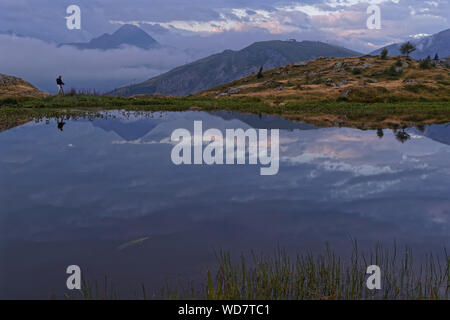 SAINT-Sorlin, FRANCE, Août 10, 2019 Photographe : tire un paysage d'un lac de montagne dans la première lumière de l'aube. Banque D'Images