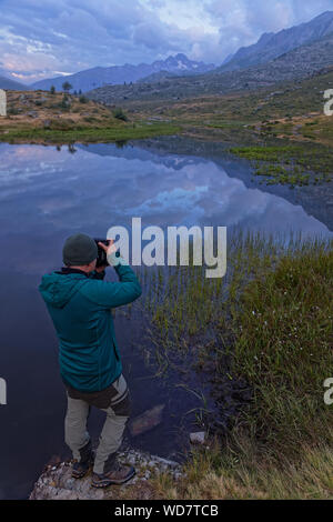 SAINT-Sorlin, FRANCE, Août 10, 2019 Photographe : tire un paysage d'un lac de montagne dans la première lumière de l'aube. Banque D'Images