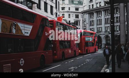 Londres, Royaume-Uni - Aug 01, 2019 : un beau coup de gens qui marchent sur le trottoir avec trois bus rouge sur la rue Banque D'Images