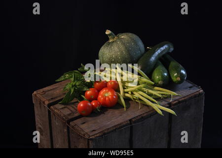 Une sélection de légumes du jardin, tomates Beefsteak, les haricots verts, les courgettes et les feuilles de basilic Banque D'Images