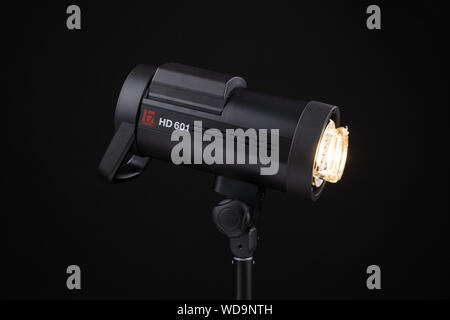 Studio photo flash stroboscopique monobloc de l'ampoule. Vue rapprochée de la lampe flash de studio professionnel sur fond noir. Piaggio Vespa lampe flash sur l'anneau. Banque D'Images