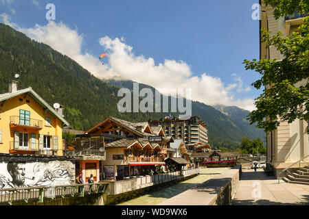 Vue panoramique de la ville alpine de Chamonix-Mont-Blanc avec de l'Arve et d'un parapente en vol au-dessus des Alpes françaises, Haute Savoie, France Banque D'Images