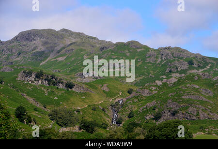 Wainwright Le Tarn et la chute d'Sourmilk Crag Gill de Easedale Près de Grasmere dans le Parc National du Lake District, Cumbria, England, UK. Banque D'Images