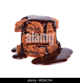 Tranches de brownie, isolé sur fond blanc, couvert de sirop au chocolat noir. Banque D'Images
