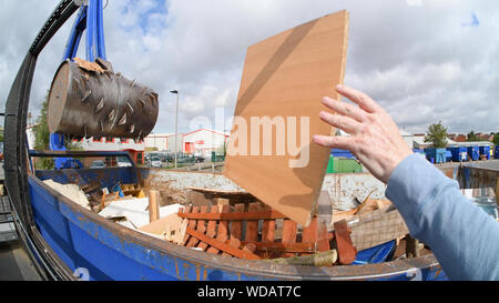 Man throwing bois en aller pour le traitement par bras hydraulique bois de trituration au centre de recyclage des déchets ménagers united kingdom Banque D'Images