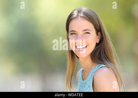 Portrait d'une femme heureuse avec sourire blanc parfait regarde ailleurs dans un parc Banque D'Images