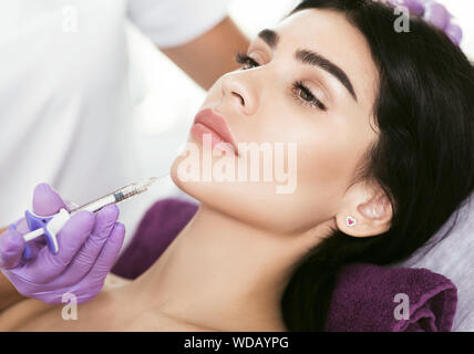 Traitement visage cosmétique. Belle femme d'âge moyen se font face à l'injection, l'effet de levage, la beauté les injections pour l'ascenseur de visage et contour visage serrer Banque D'Images