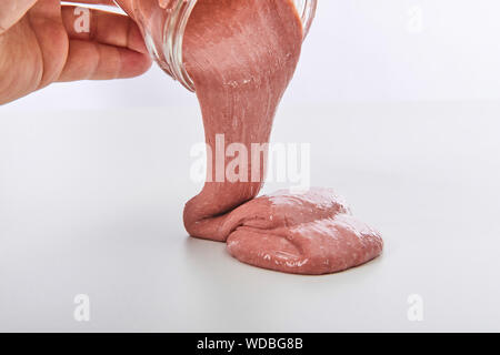 Appelé jouet Slime déversant du pot sur fond blanc Banque D'Images