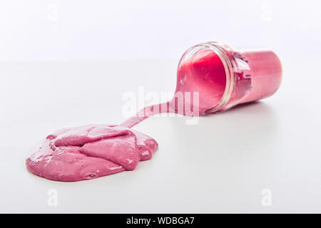 Appelé jouet Slime déversant du pot sur fond blanc Banque D'Images