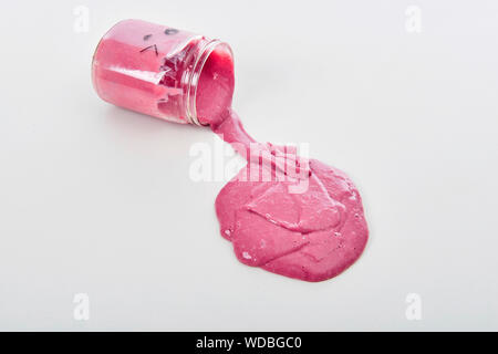 Appelé jouet Slime déversant du pot sur fond blanc Banque D'Images