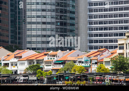 Des boutiques traditionnelles conservées à Boat Quay ont été converties en restaurants et bars principalement. Immeubles commerciaux de grande hauteur à l'arrière, Singapour. Banque D'Images