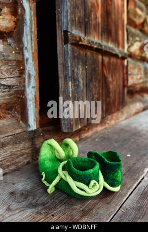 Elf créature féerique ou la forêt gauche naine ses chaussures sur le seuil d'une vieille maison de bois près de la porte