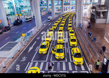 Groupe de taxis jaunes en attendant l'arrivée de passagers en face de la porte de l'aéroport. L'aéroport international Jiangbei de Chongqing Jiangbei de Chongqing, Chine. Banque D'Images