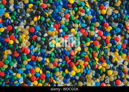 Colorant polymérique colorés industriels. Granules de plastique. Colorant pour les matières plastiques. Pigment dans la texture de fond des granules de polyéthylène en plastique. Banque D'Images