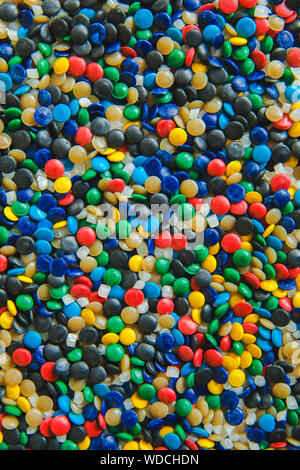 Colorant polymérique colorés industriels. Granules de plastique. Colorant pour les matières plastiques. Pigment dans la texture de fond des granules de polyéthylène en plastique. Banque D'Images