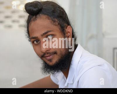 Jeune Indien dévot Sikh se penche sur l'appareil photo avant d'étroits son traditionnel turban sikh (dastar). Banque D'Images